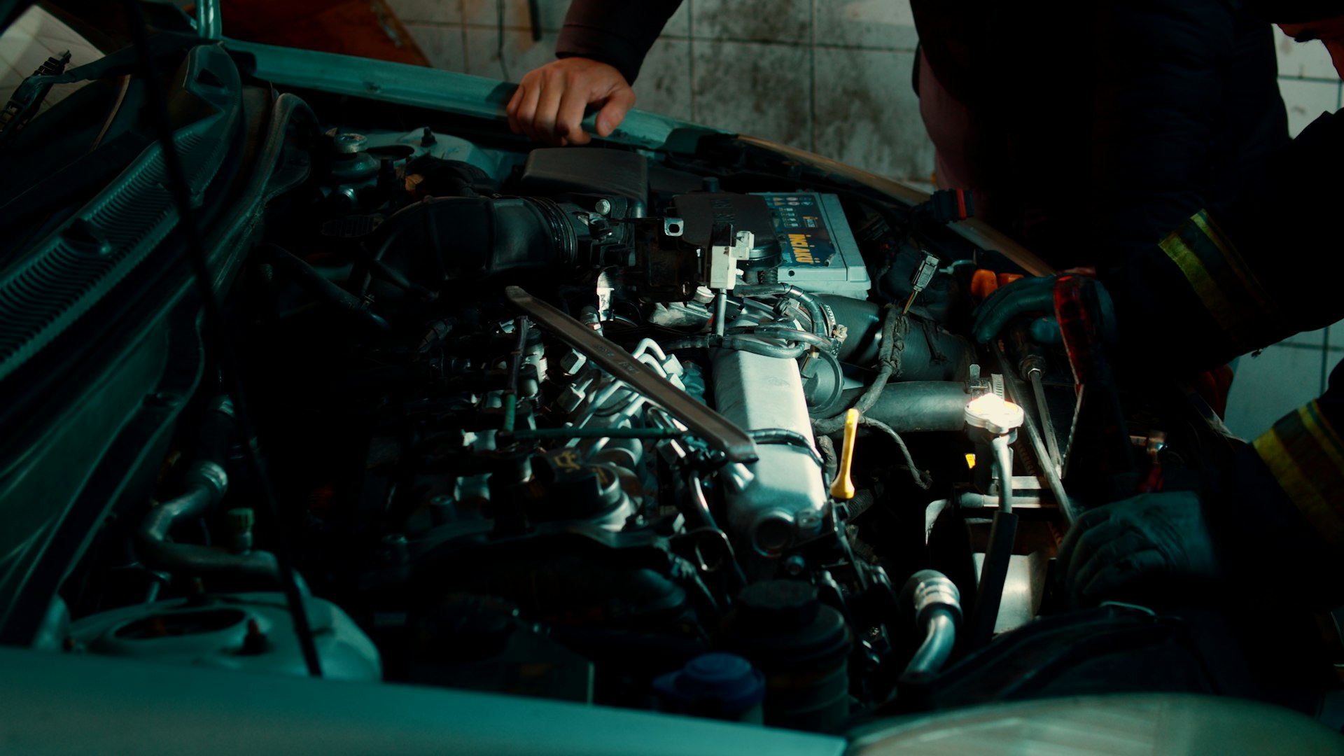 A man working on a car engine in a garage